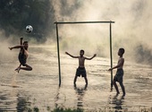 Enfants jouant au football Photos
